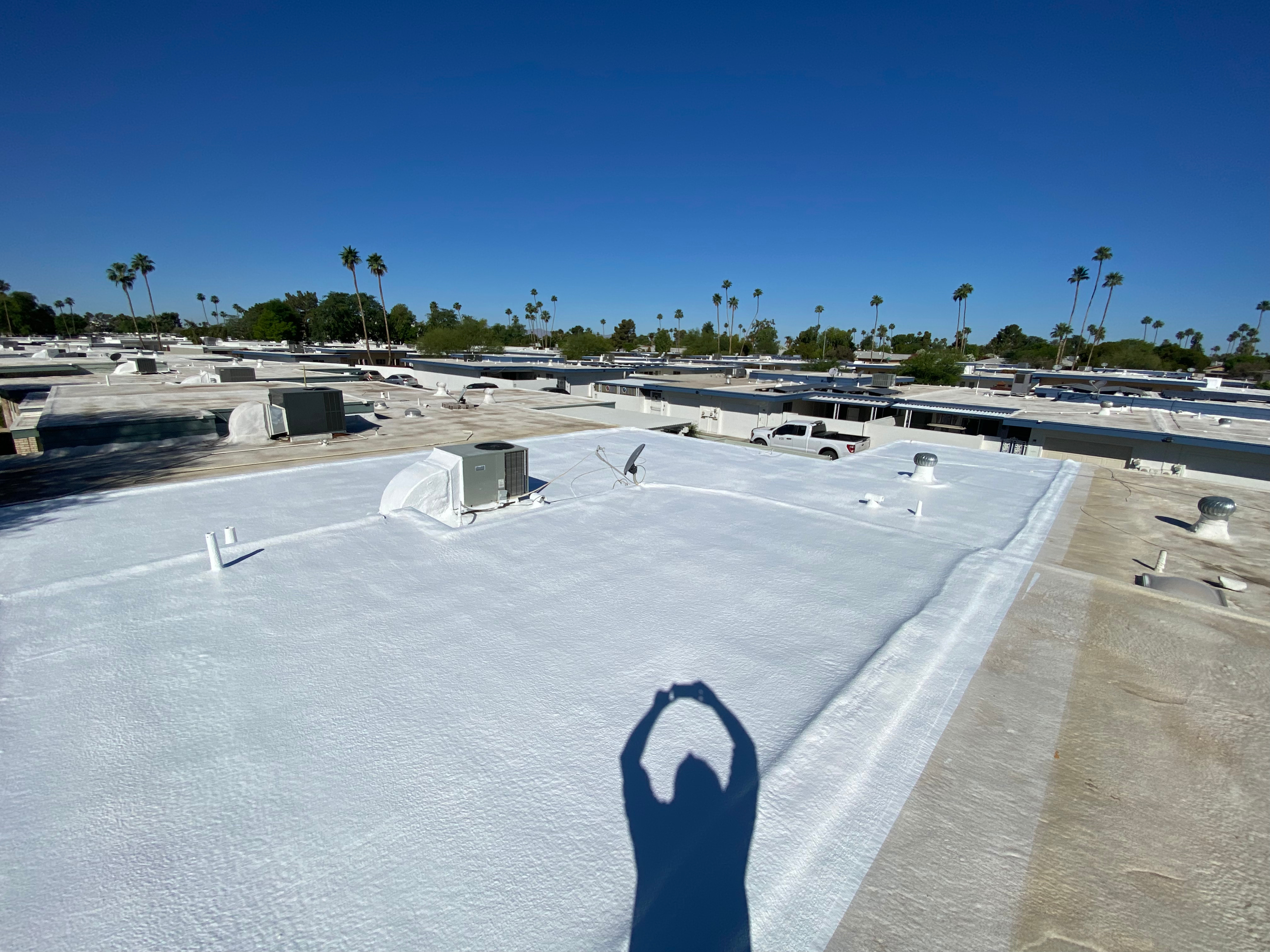 Foam roof recoat in progress on a flat-roof building in Sun City, Arizona.