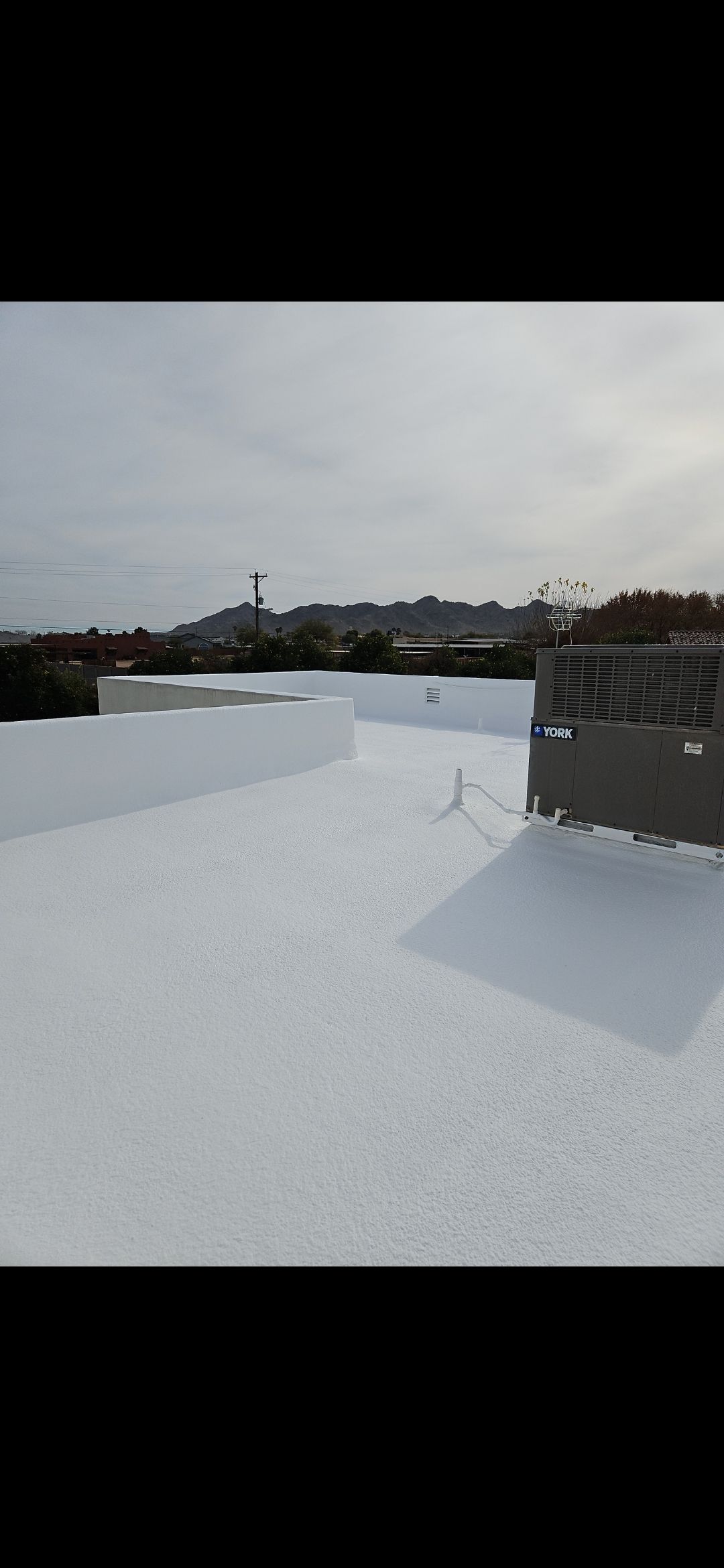 Elastomeric coating being sprayed on a Phoenix commercial roof