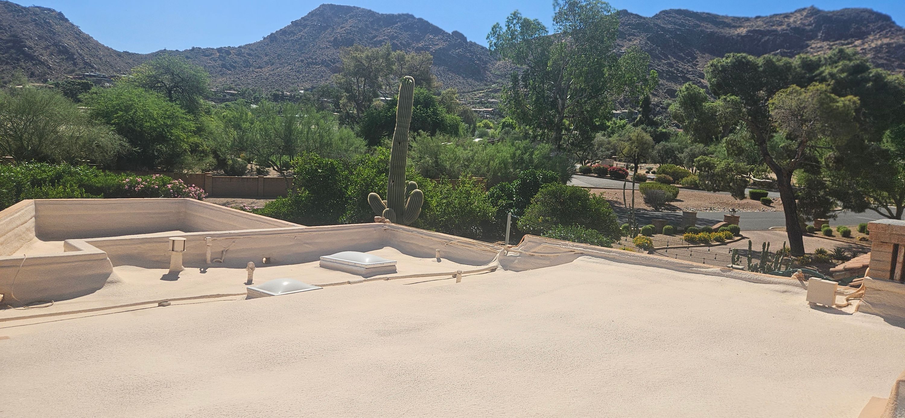 Newly installed white foam roof with two replaced skylights on a Phoenix flat-roof home